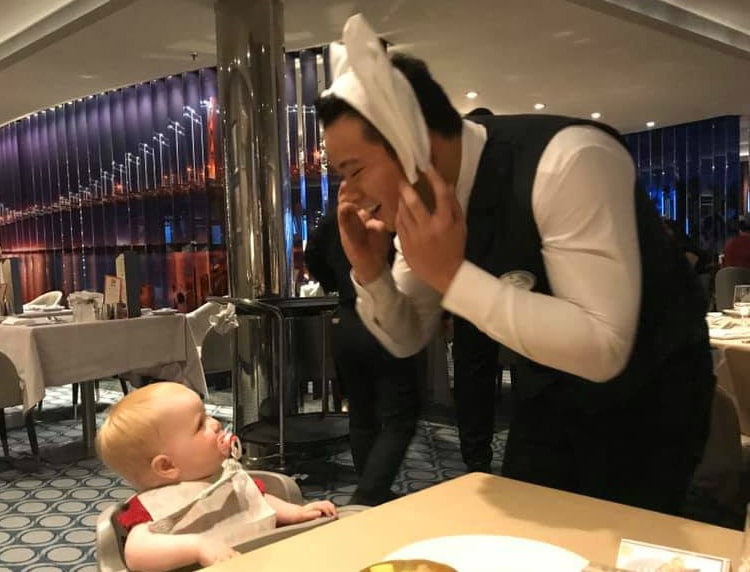 Royal Caribbean waiter entertaining baby