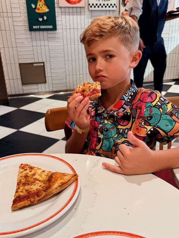 Adam eating pizza at Sorrentos on Legend of the Seas