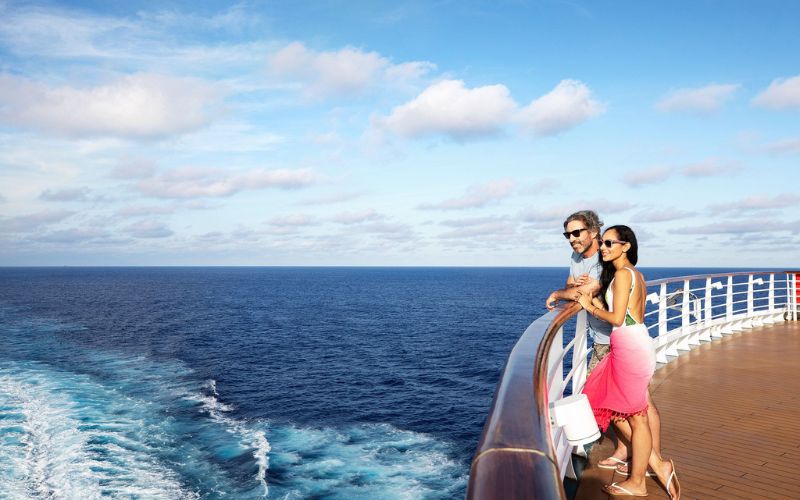 people standing by cruise ship railings