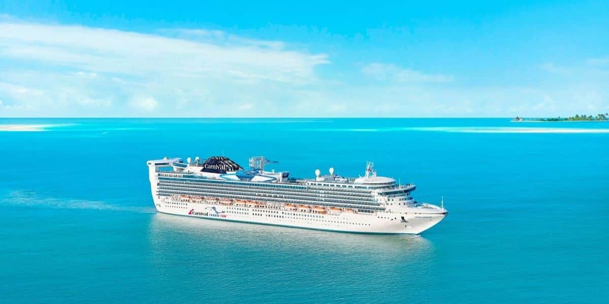 Carnival Adventure cruise ship sailing on a blue ocean.