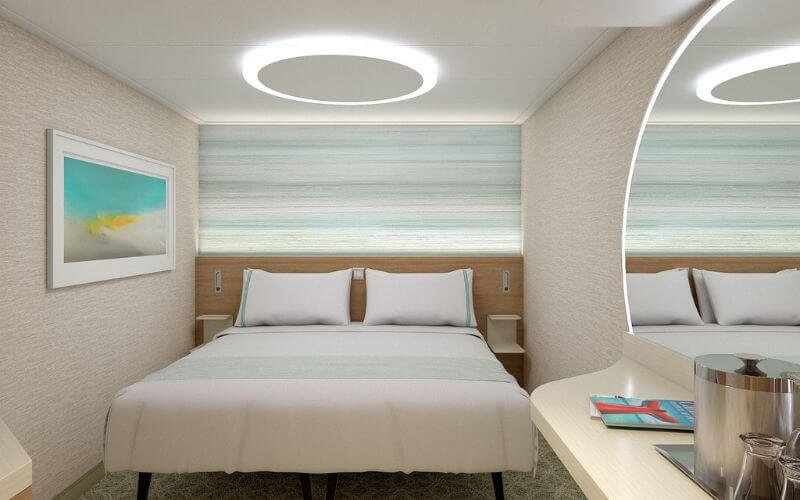 A clean-looking Cloud 9 Spa Staterooms with an eminent white motif . There's also a hanging painting beside the bed with a circular light source above