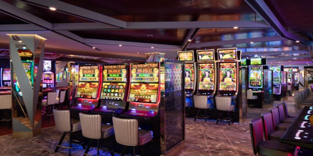 A vibrant casino floor filled with a variety of colorful slot machines, all unoccupied, in a well-lit gaming area. The scene captures the essence of modern gambling with bright displays and the allure of potential jackpots.