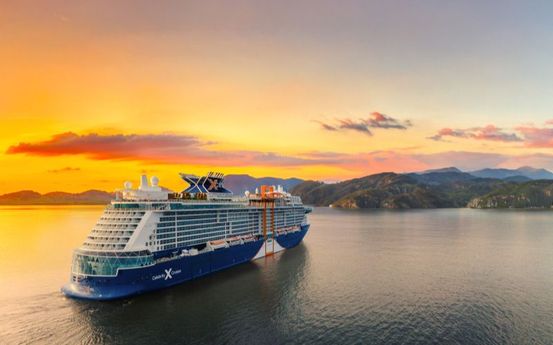 The brand new Celebrity Xcel cruising through the beautiful bright orange sunset.