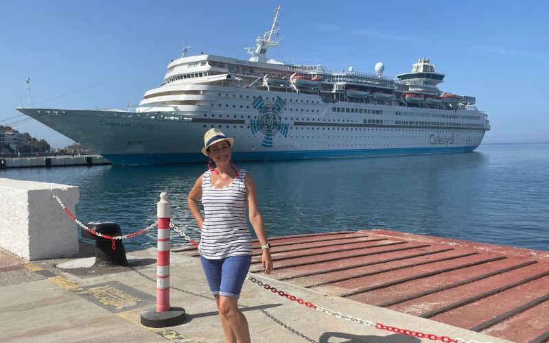 Woman standing in front of Celestyal Olympia cruise ship