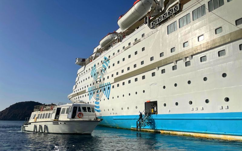 Tender boat beside Celestyal Olympia cruise ship