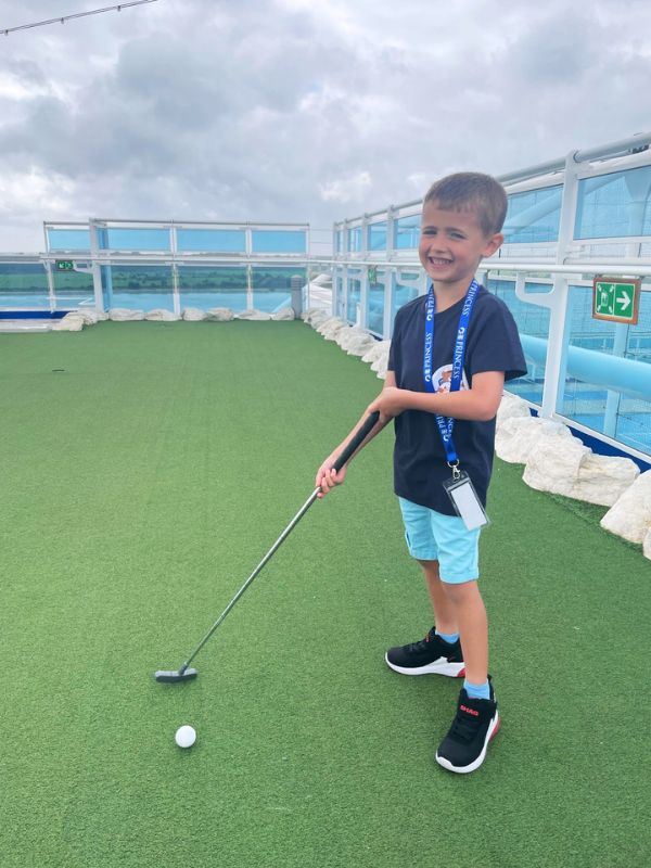 My son playing golf on Sky Princess