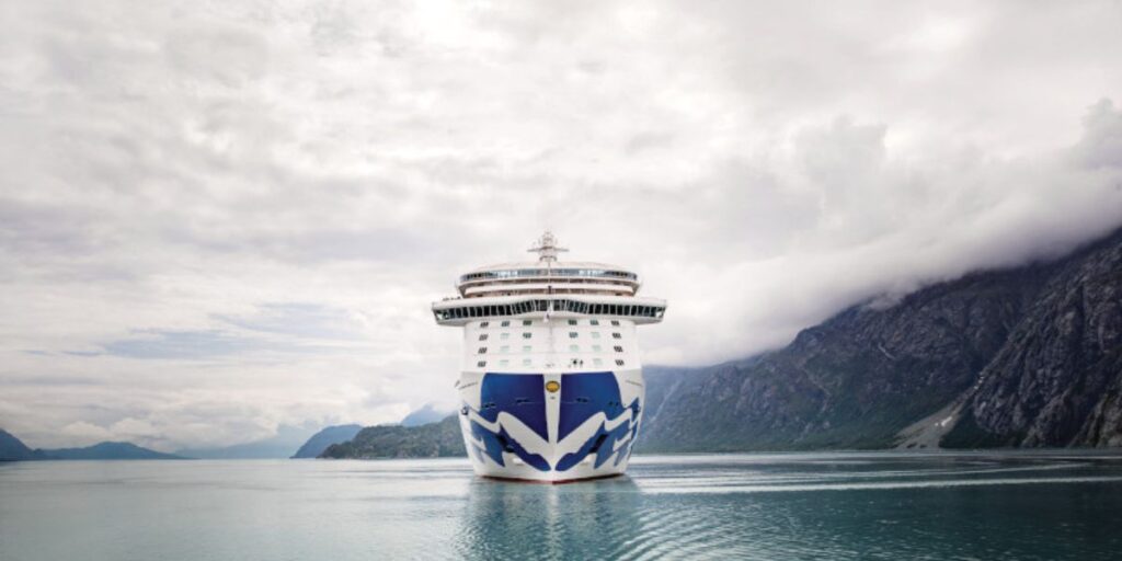 Princess Cruises ship sailing with mountains in the backdrop.