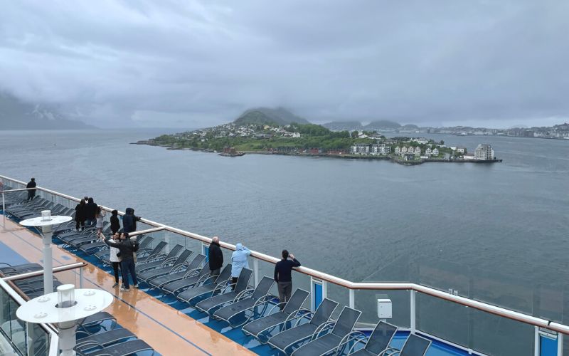 People on the cruise ship's deck  looking at the view