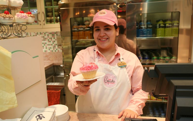Lady serving a cupcake at Cupcake Cupboard