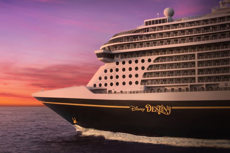 The front portion of the brand new Disney Destiny cruising through the ocean during the purplish-orange sunset