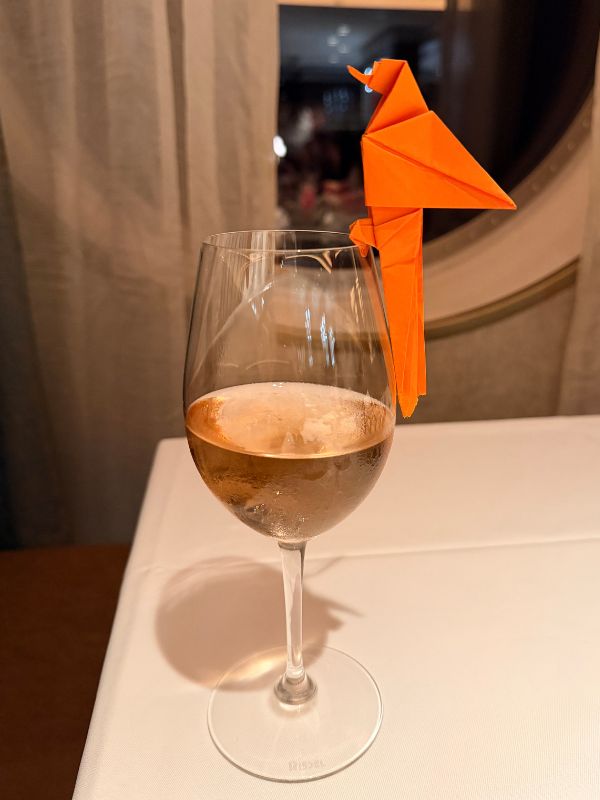 glass of wine with origami bird