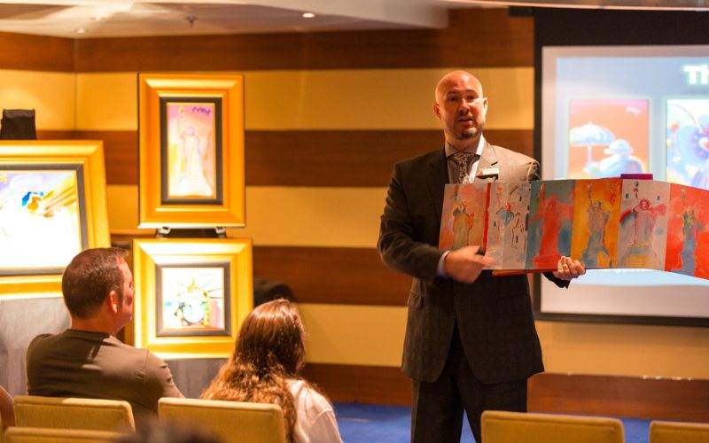 man holding an artwork in front of a group