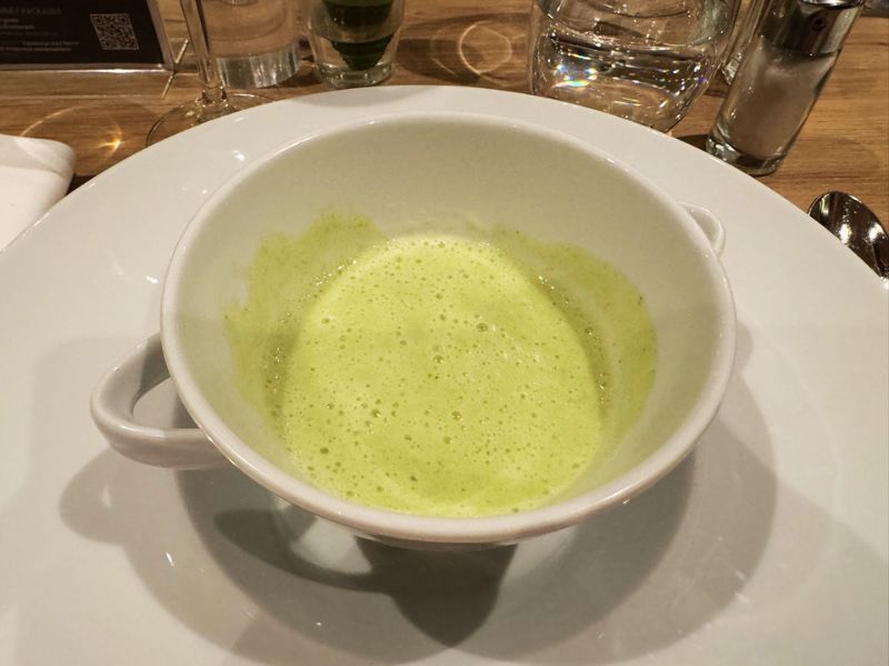 A creamy green pea soup served in a white bowl, capturing the simplicity and elegance of dining aboard the Costa cruise ship.