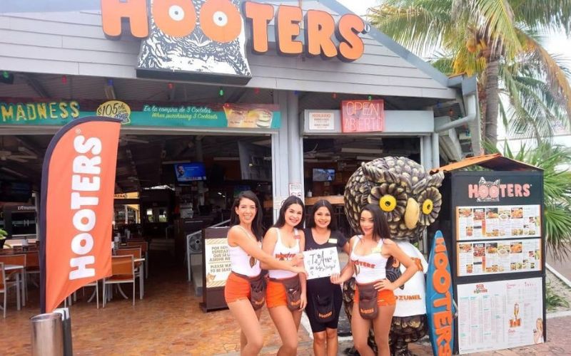 Women standing outside Hooters Cozumel