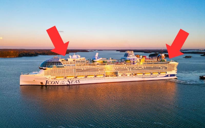 Aerial view of Royal Caribbean's 'Icon of the Seas' during sunset, highlighting two prominent features with red arrows pointing at them. The ship is seen cruising through calm waters, showcasing its massive structure and colorful top deck activities including water slides and pools, against a backdrop of scattered islands under a glowing sky.