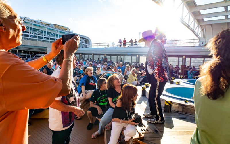 People on a cruise ship having fun with a performer on stage