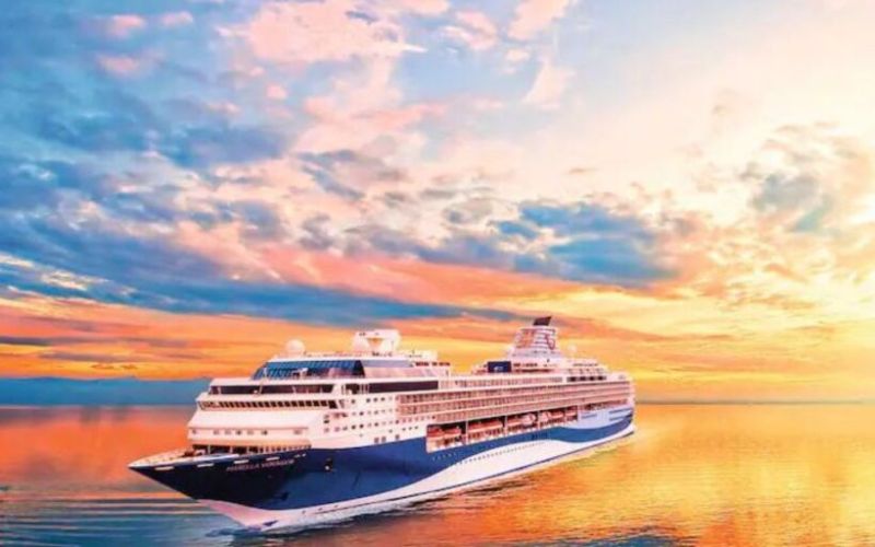 Marella voyager cruising the sea during a wonderful sunset posing a majestic reflection on the water