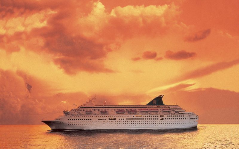 Norwegian Majesty cruising the ocean under the orange sunset sky