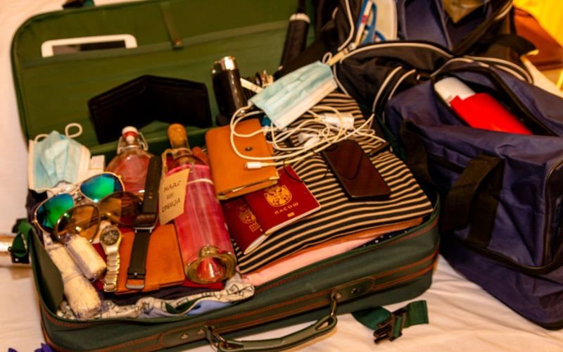 Open suitcase packed for holiday on bed at home