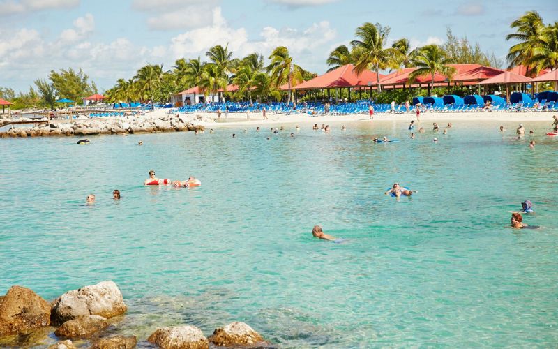 People enjoying a relaxing swim at Princess Cays' beach