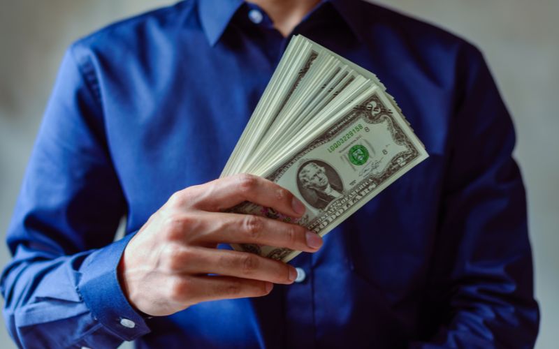 Person holding $2 dollar bills