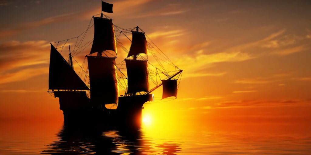 An old pirate ship sailing in the sunset