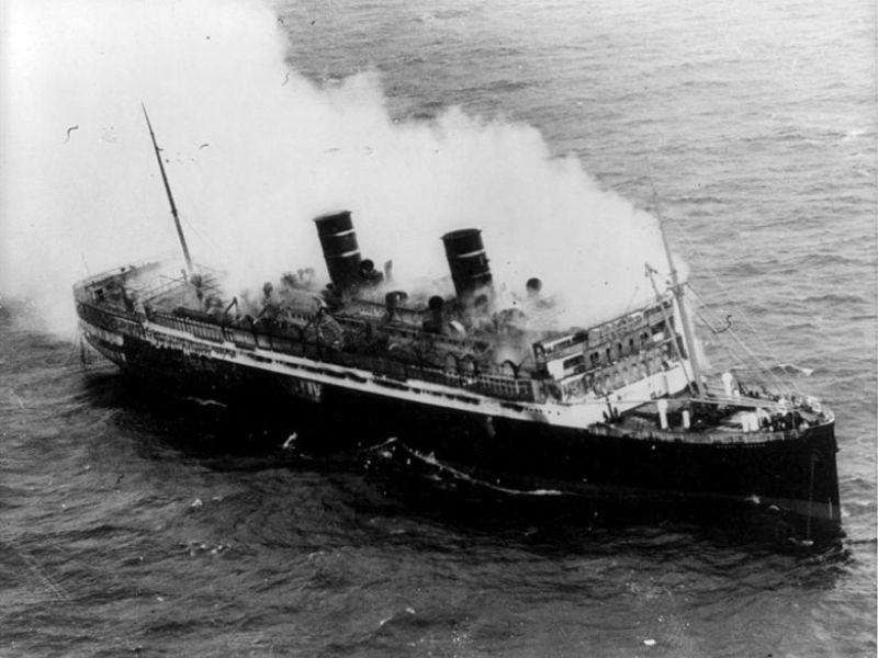 Historic black and white photo of the SS Morro Castle engulfed in smoke due to a tragic fire at sea, illustrating a dramatic moment in maritime disaster history.