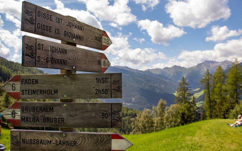 A pole with 6 signs pointing to different directions of locations in Norway.