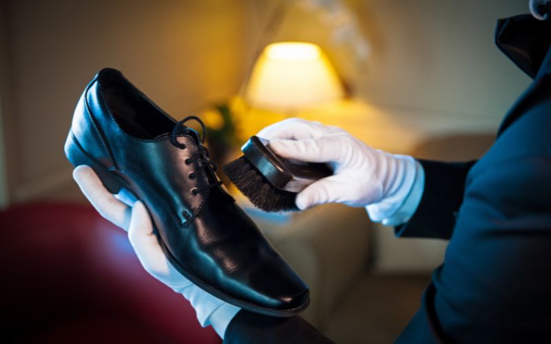 A butler on a Silversea cruise ship provides meticulous shoe shining service, highlighting the exceptional personal care and attention to detail offered to guests aboard the luxury liner.