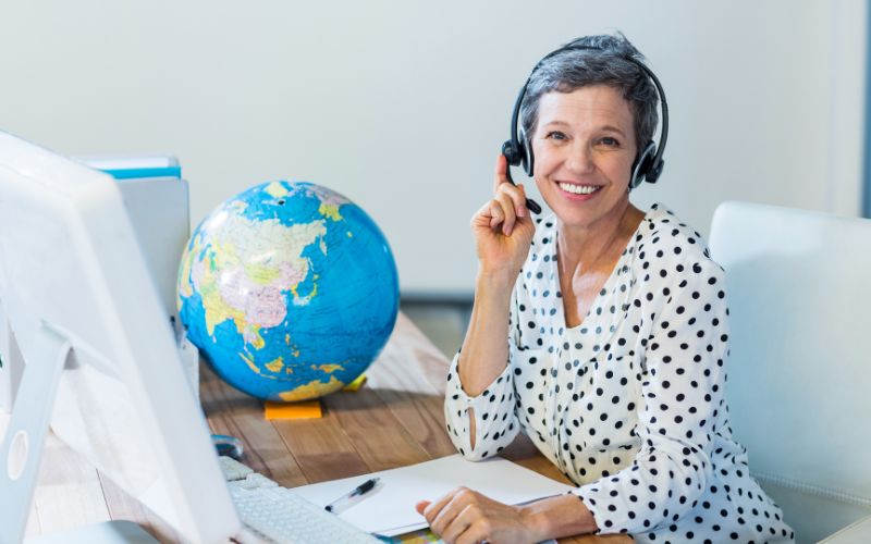 Smiling travel agent sitting at her desk