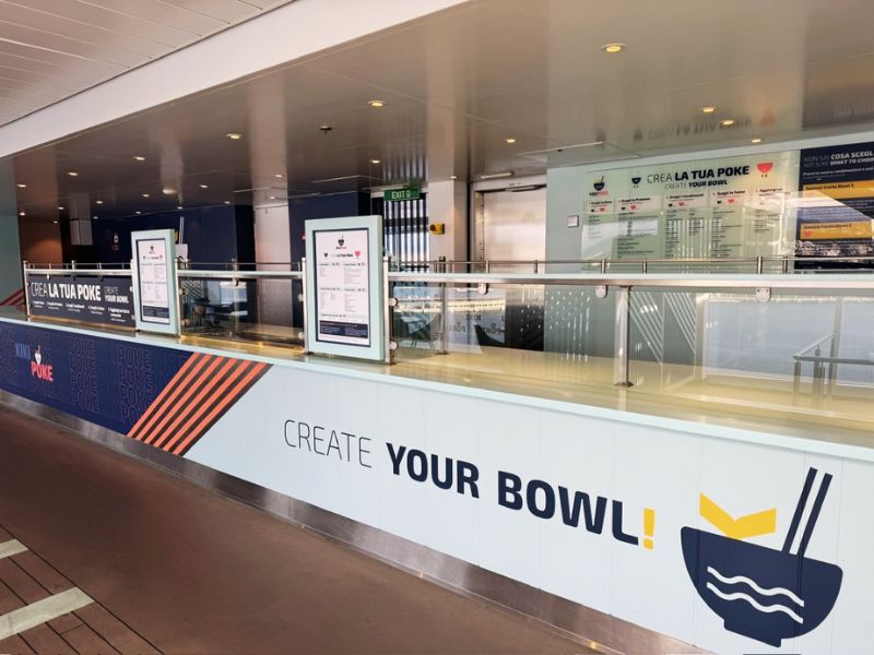 The specialty poke bowl restaurant on the Costa Smeralda, featuring a 'Create Your Bowl' concept, with signage and menu boards inviting guests to customize their meal.