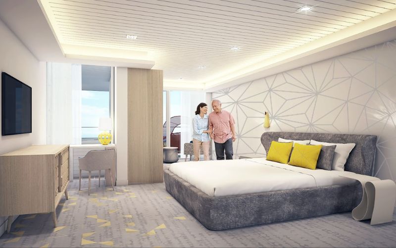 A digital illustration of the bedroom area within the Ultimate Family Suite aboard Royal Caribbean's Spectrum of the Seas, featuring a large bed with gray and yellow accents, a cozy seating area, and a couple standing and embracing, with ocean views through the window.