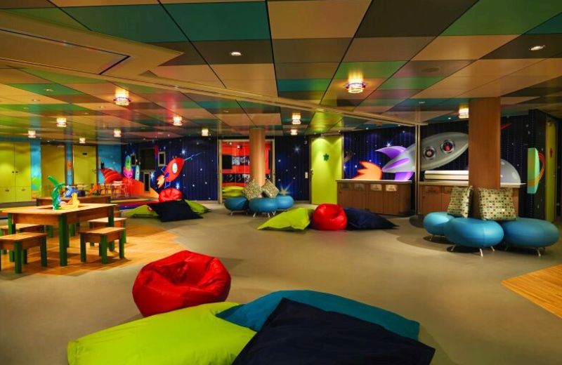 Vibrant children's playroom at Splash Academy on NCL Getaway, featuring colorful bean bags, interactive games, and whimsical decorations, providing a fun and engaging space for young cruisers.