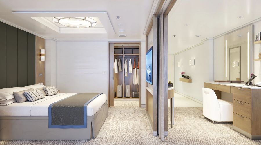 The sophisticated Signature Owner’s Suite on Sun Princess, featuring a plush bed, an open wardrobe, a well-lit vanity area, and a modern design that exudes luxury and comfort for guests.