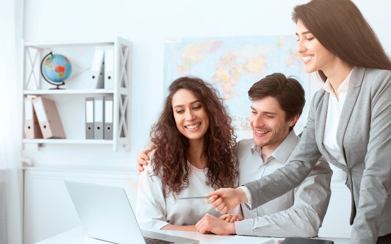 Smiling couple booking a cruise with a travel agent