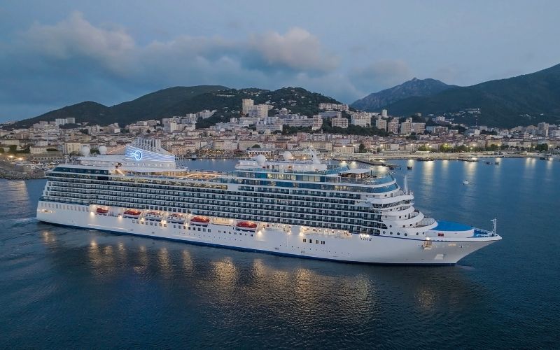 Vista cruise ship from Oceania Cruises leaving a small island town as the night approach