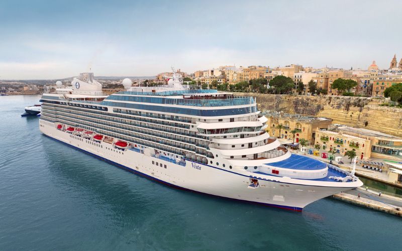 Oceania Cruises vista docked near a small town
