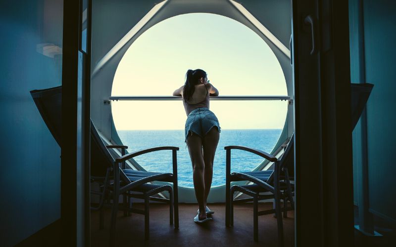 Woman Relaxing on Cruise Ship Enjoying Ocean View from Balcony