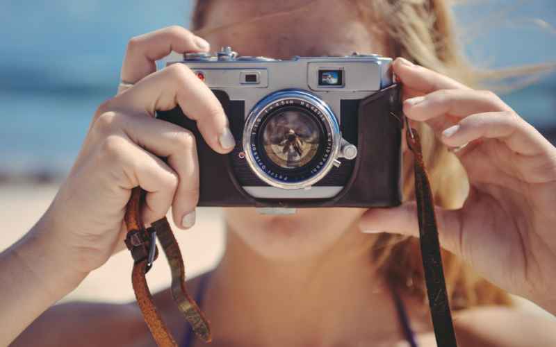 A woman taking a photo with a camera.