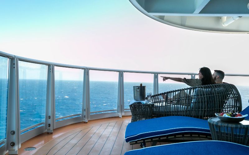 a couple relaxing on the balcony of a Carnival cruise ship's suite