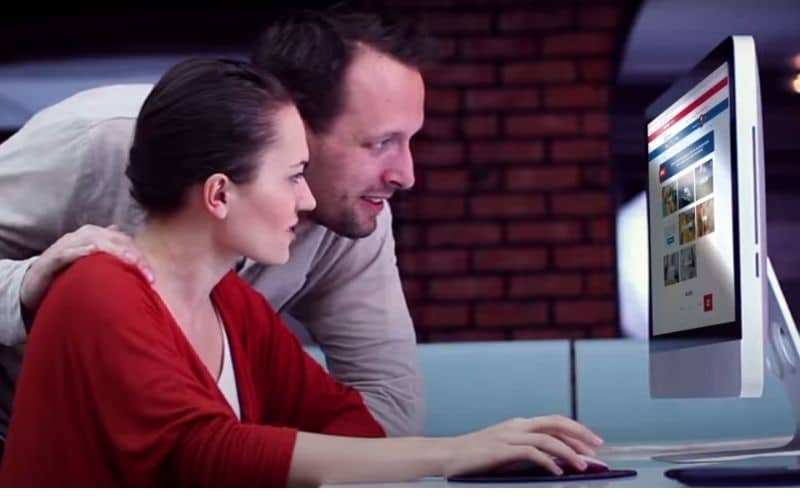 Man assisting a woman on the computer