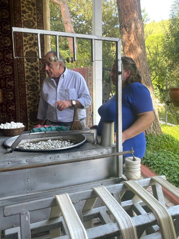 man and woman watching carpet making using silkworm