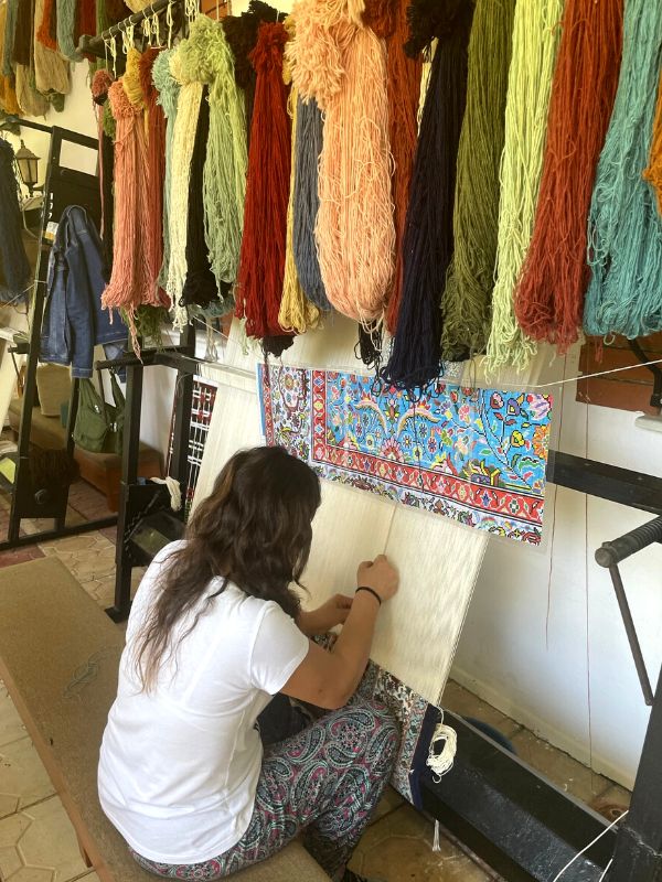 woman in the process of making a carpet