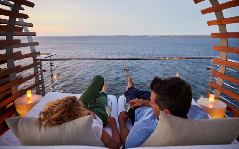Couple sharing a glass of champagne on Celebrity Cruises balcony