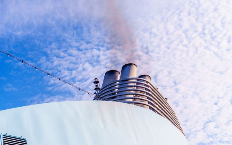 Large cruise ship pollutes the atmosphere through smoke from pipe