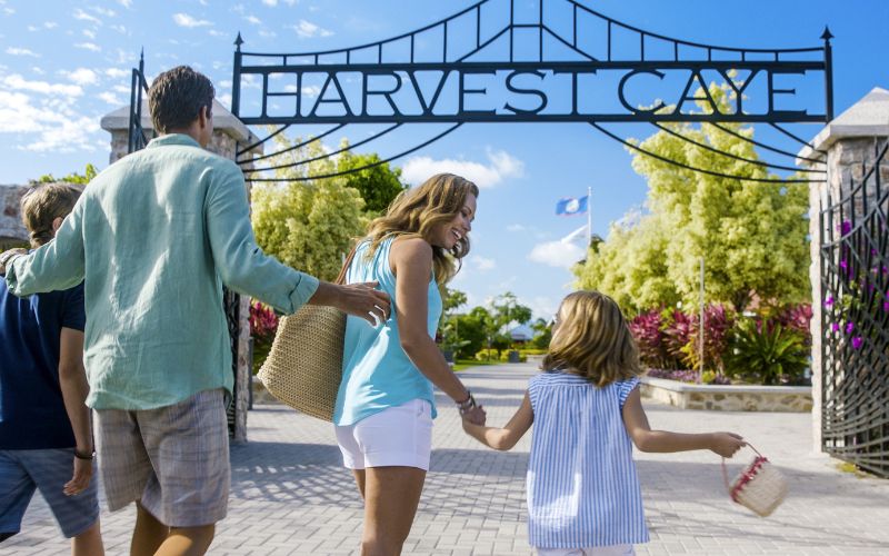 Excited family entering Harvest Caye front gate