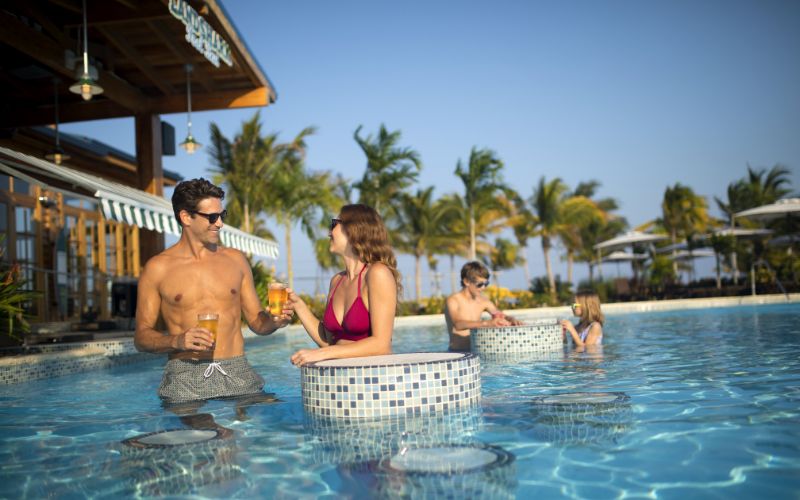 Couple having a drink and enjoying at Harvest Caye Pool Bar