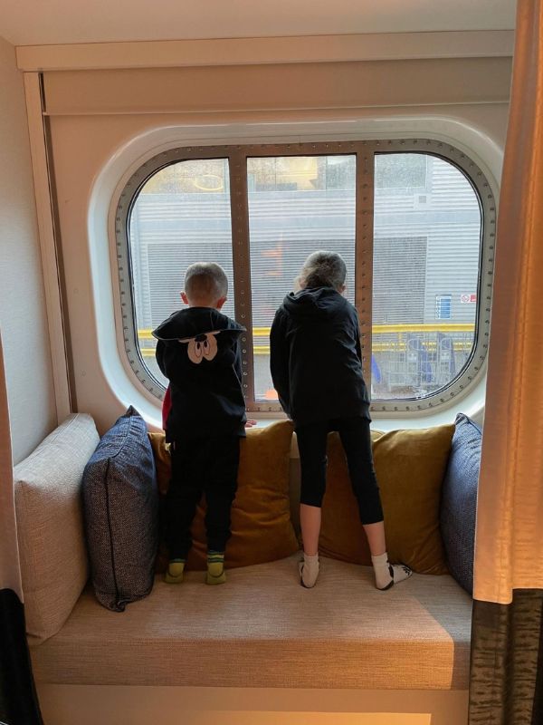 Kids looking out the window of a cruise ship