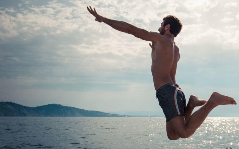 man jumping into sea from a ship