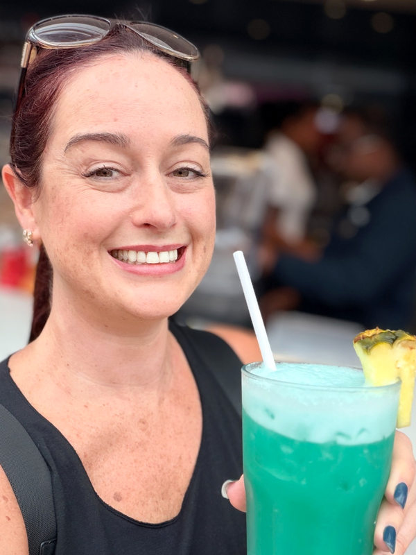Me holding a bright blue cocktail on MSC Virtuosa